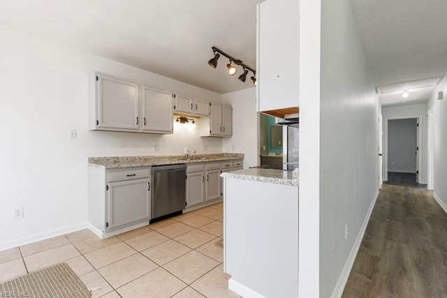 kitchen featuring light tile patterned floors, sink, black electric stovetop, track lighting, and stainless steel dishwasher