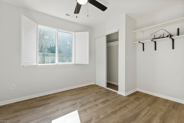 unfurnished bedroom with hardwood / wood-style floors, a closet, and ceiling fan