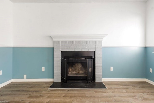 details featuring hardwood / wood-style floors and a brick fireplace