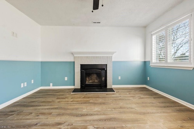 unfurnished living room featuring hardwood / wood-style floors, a textured ceiling, and ceiling fan