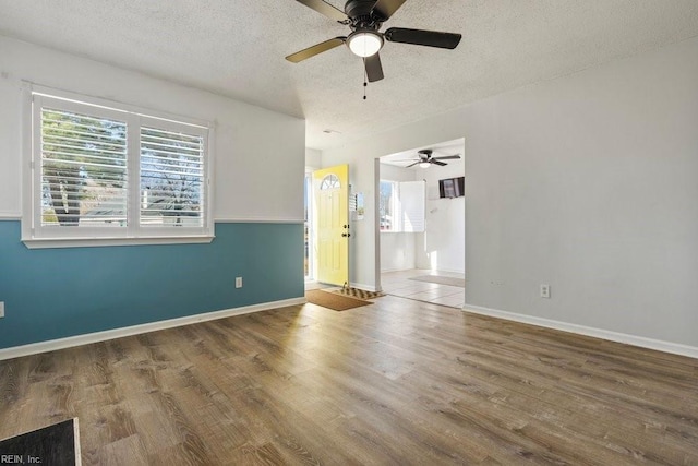 unfurnished room with hardwood / wood-style flooring and a textured ceiling