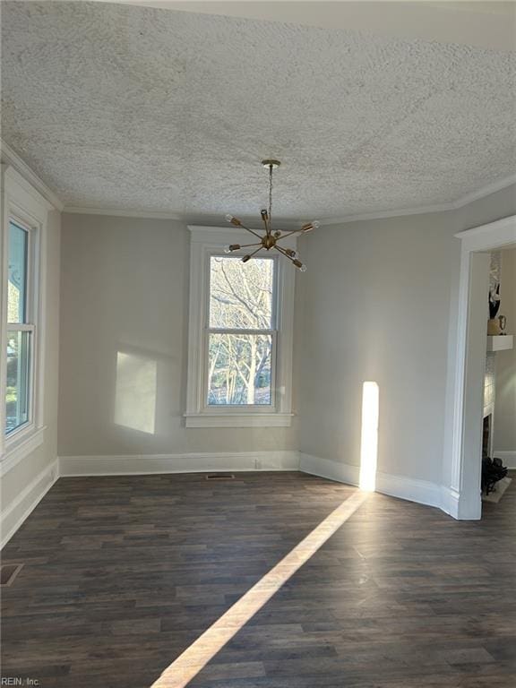 empty room with a notable chandelier, crown molding, and dark hardwood / wood-style floors