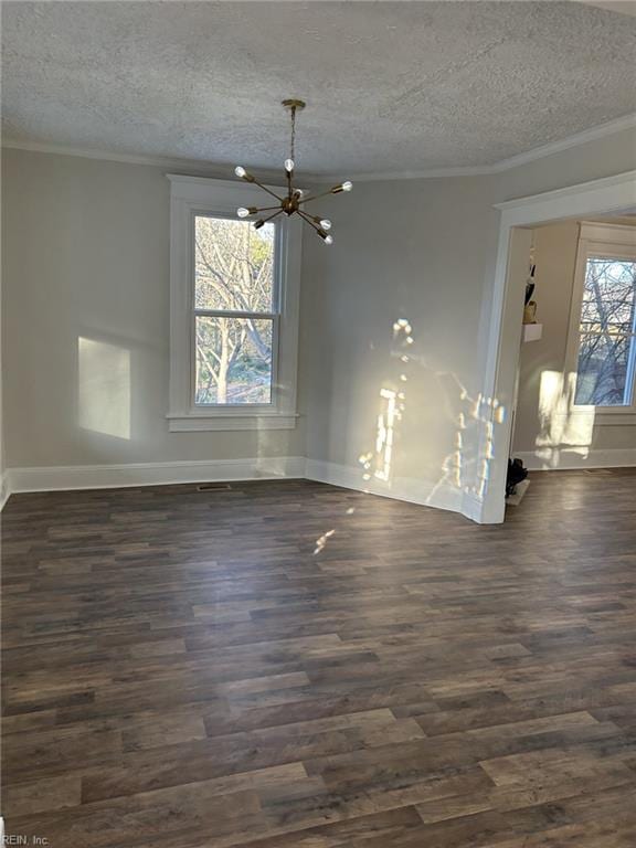 interior space featuring crown molding, an inviting chandelier, a textured ceiling, and dark hardwood / wood-style flooring