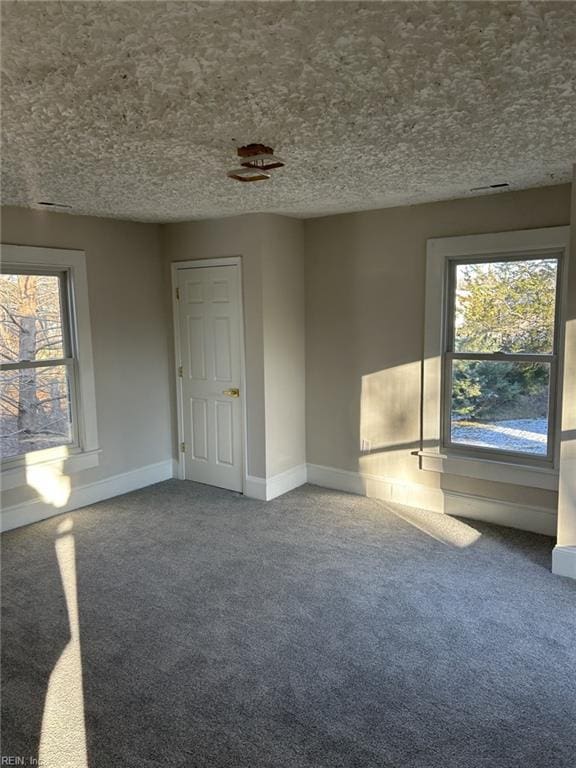 empty room with a textured ceiling and carpet flooring