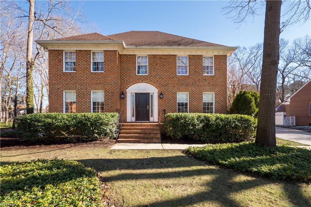 colonial home featuring a front lawn