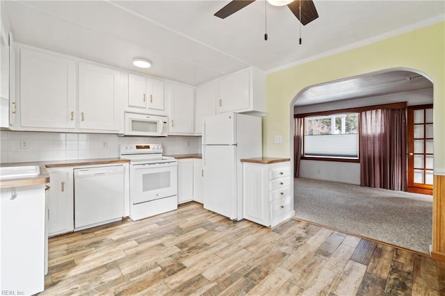 kitchen with white appliances, backsplash, ceiling fan, light hardwood / wood-style floors, and white cabinetry