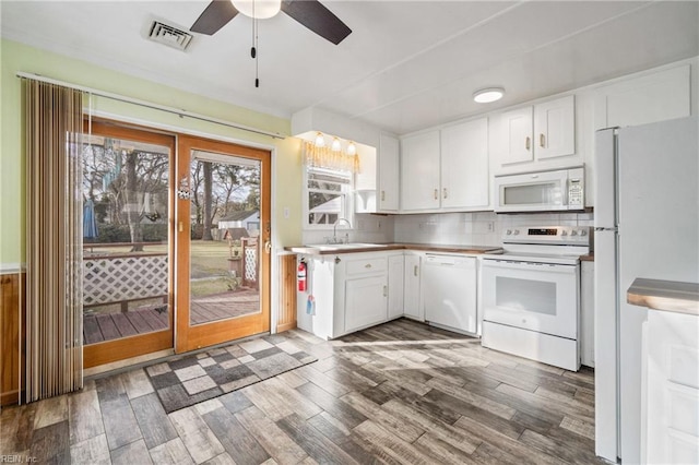 kitchen with dark hardwood / wood-style flooring, tasteful backsplash, white appliances, ceiling fan, and white cabinetry