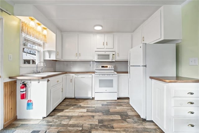 kitchen featuring decorative backsplash, dark hardwood / wood-style flooring, white appliances, sink, and white cabinets