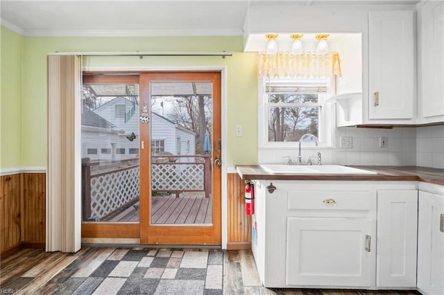 doorway featuring crown molding, sink, and dark wood-type flooring