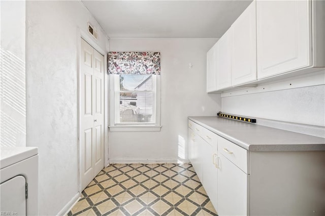 laundry room with light tile patterned flooring, cabinets, and washer / clothes dryer