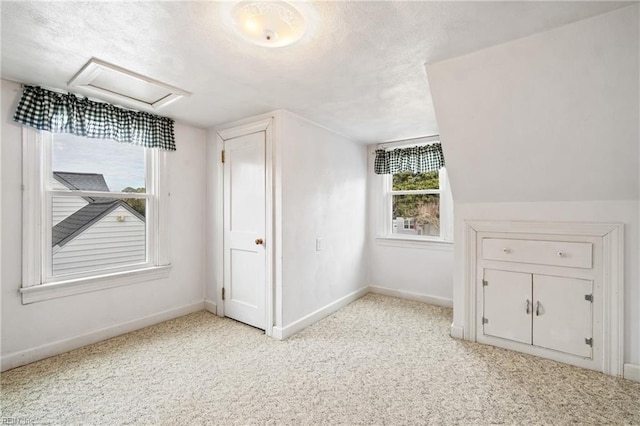 additional living space with light colored carpet and vaulted ceiling