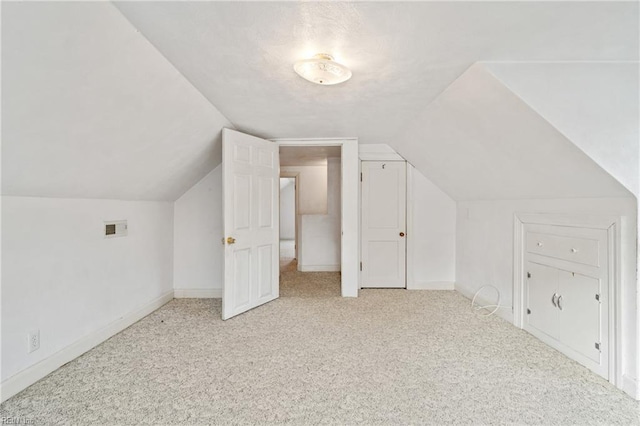 additional living space with light colored carpet and lofted ceiling