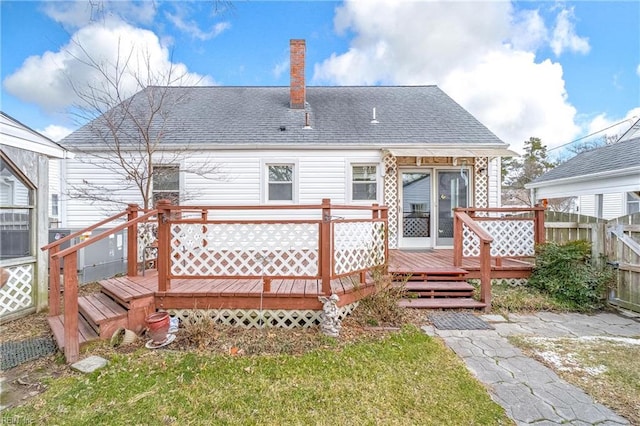 rear view of property with a yard and a wooden deck