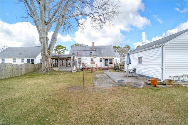 rear view of property with a yard, a patio area, and a wooden deck