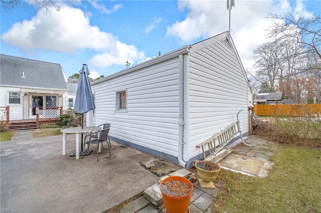 view of property exterior featuring a patio, a deck, and a lawn