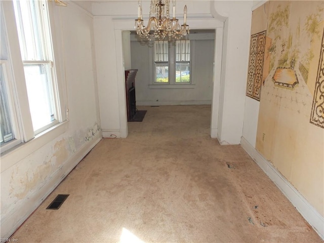 unfurnished dining area with light carpet and a notable chandelier