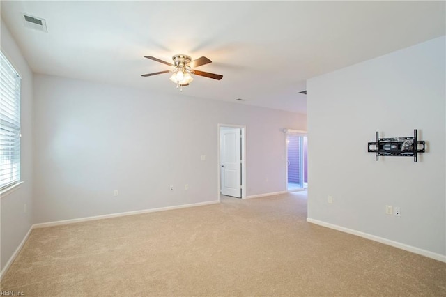 carpeted empty room featuring ceiling fan and plenty of natural light