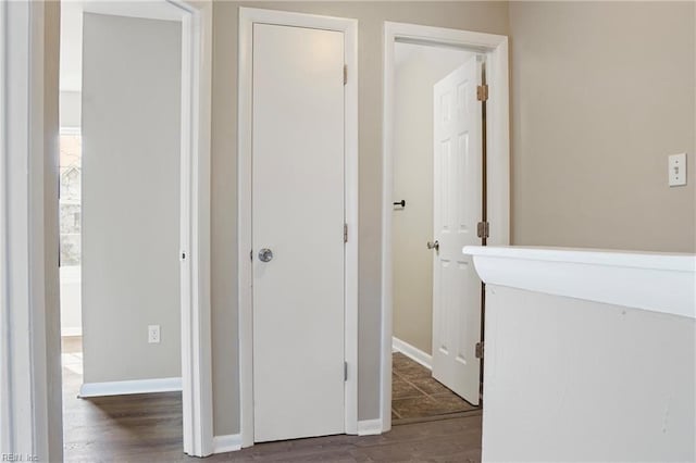 hallway with baseboards and wood finished floors