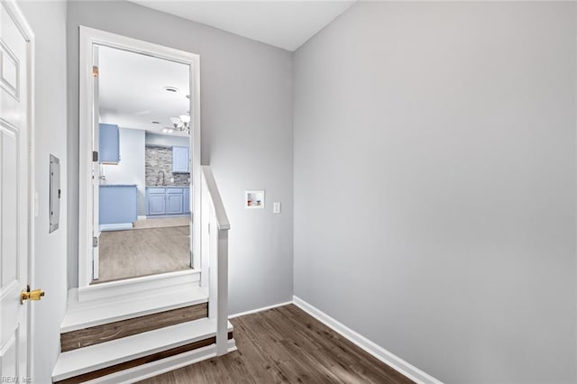 stairs with hardwood / wood-style floors and sink