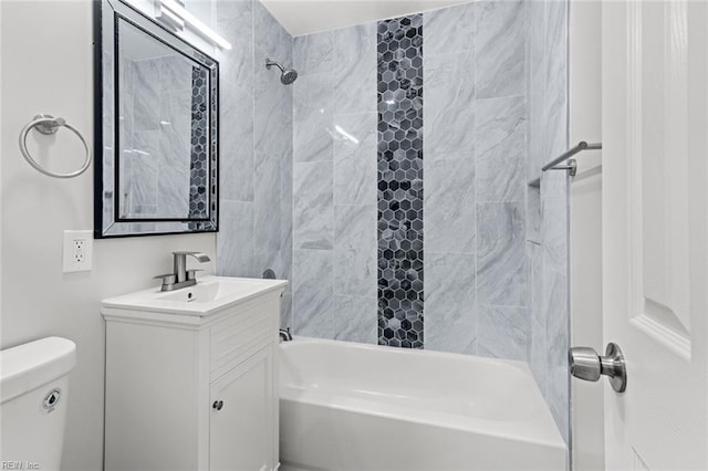 full bathroom with toilet, vanity, and tiled shower / bath