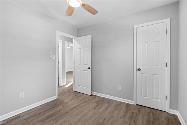 unfurnished bedroom with ceiling fan and wood-type flooring