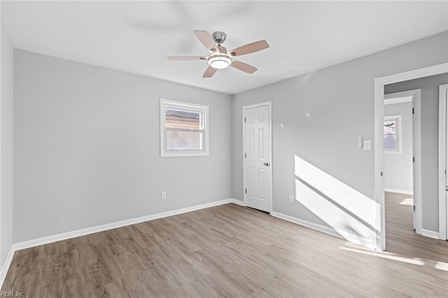 spare room with ceiling fan and light wood-type flooring