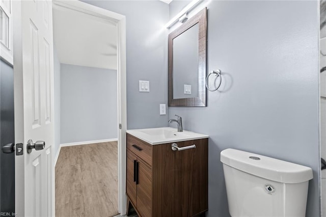 bathroom featuring toilet, vanity, and hardwood / wood-style floors