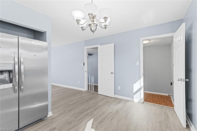 kitchen featuring stainless steel fridge with ice dispenser, an inviting chandelier, and light hardwood / wood-style flooring