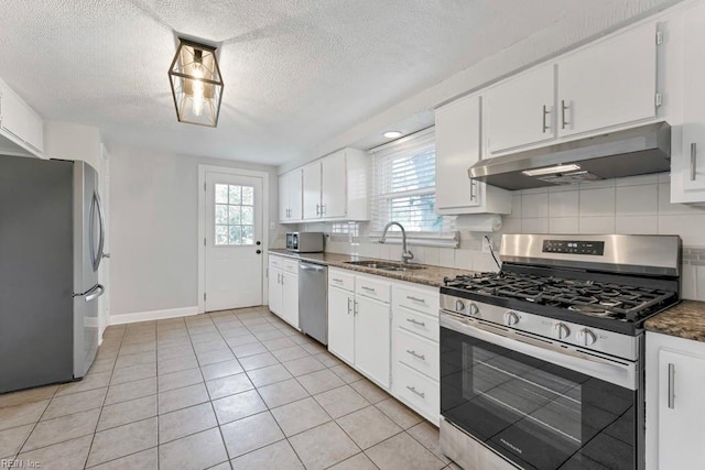 kitchen with white cabinetry, sink, tasteful backsplash, light tile patterned floors, and appliances with stainless steel finishes