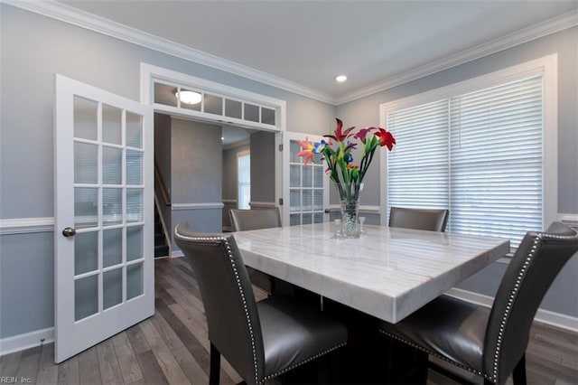 dining room with a wealth of natural light, dark hardwood / wood-style flooring, and ornamental molding