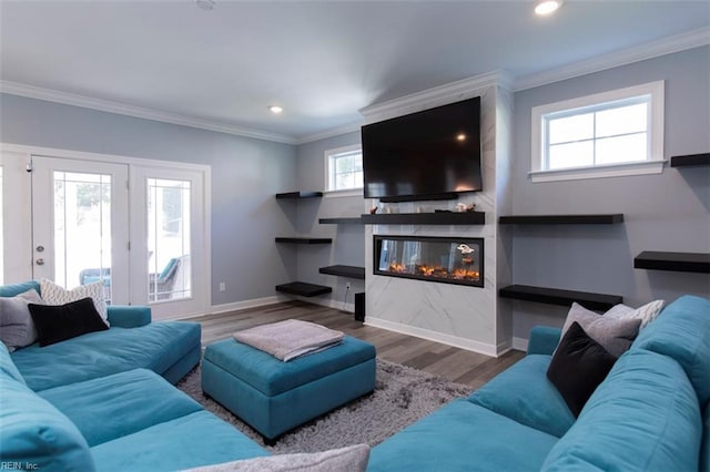 living room with crown molding, a fireplace, hardwood / wood-style floors, and french doors