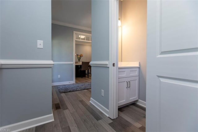 hall with dark wood-type flooring and ornamental molding