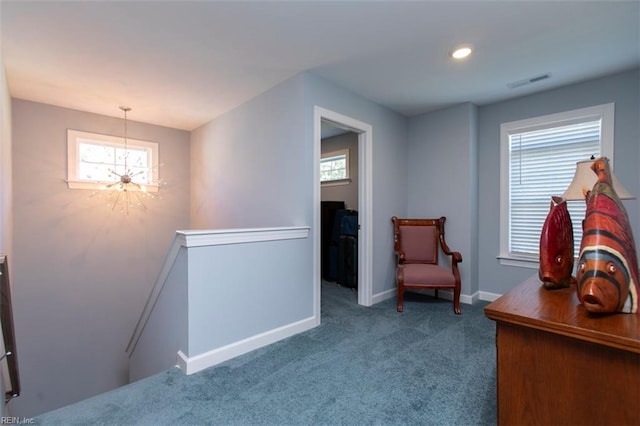 living area featuring carpet and an inviting chandelier