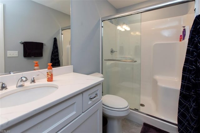 bathroom featuring tile patterned flooring, vanity, toilet, and walk in shower