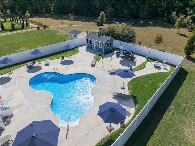 view of pool with an outbuilding, a yard, and a patio