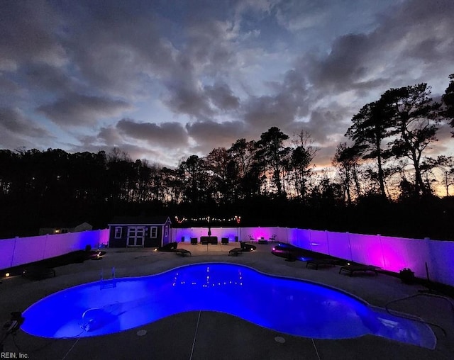 pool at dusk with an outbuilding