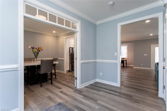 dining space featuring wood-type flooring and ornamental molding