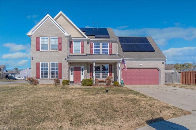 view of front of property with a garage, a front yard, and solar panels