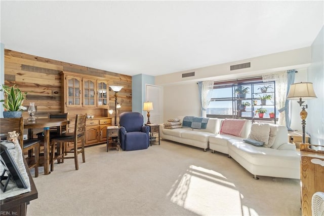 living room with light colored carpet and wood walls