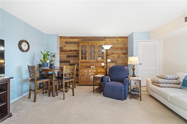 carpeted living room with wood walls