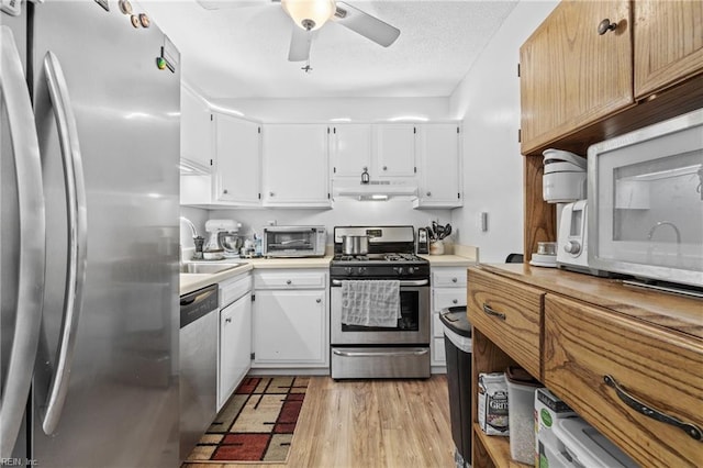 kitchen featuring appliances with stainless steel finishes, light hardwood / wood-style flooring, white cabinets, and sink