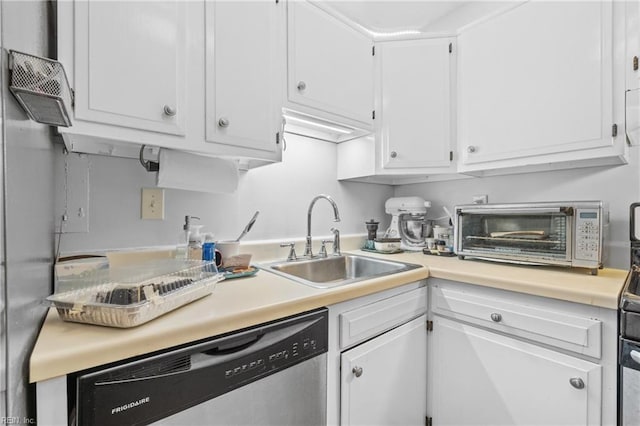 kitchen with stainless steel dishwasher, white cabinetry, and sink