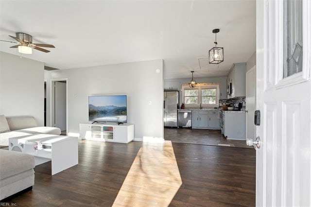 living room featuring sink, dark hardwood / wood-style flooring, and ceiling fan