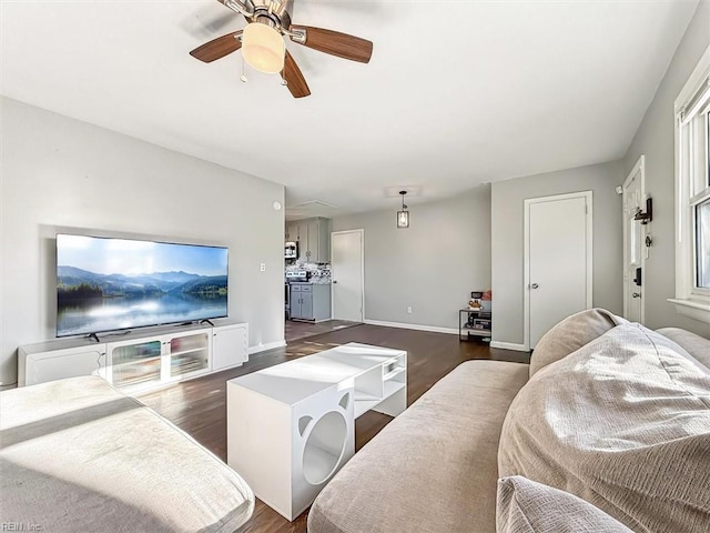 living room featuring ceiling fan and dark hardwood / wood-style floors