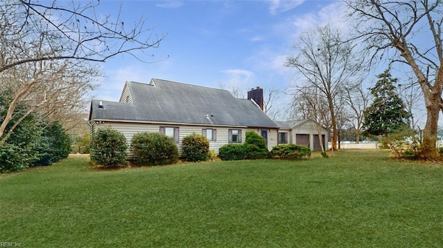 rear view of house with a garage and a lawn