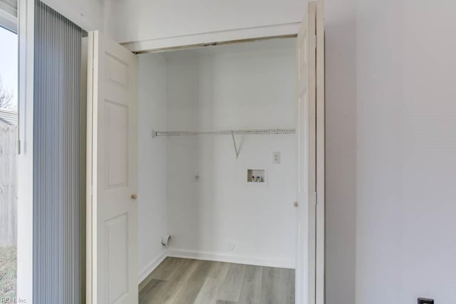 laundry area featuring hookup for a washing machine and light hardwood / wood-style flooring