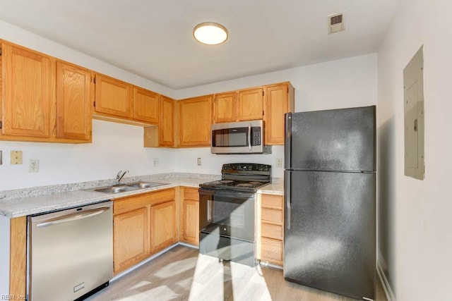 kitchen featuring light hardwood / wood-style flooring, black appliances, and sink