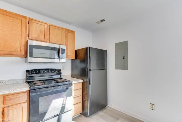 kitchen featuring light brown cabinets, light wood-type flooring, black appliances, and electric panel