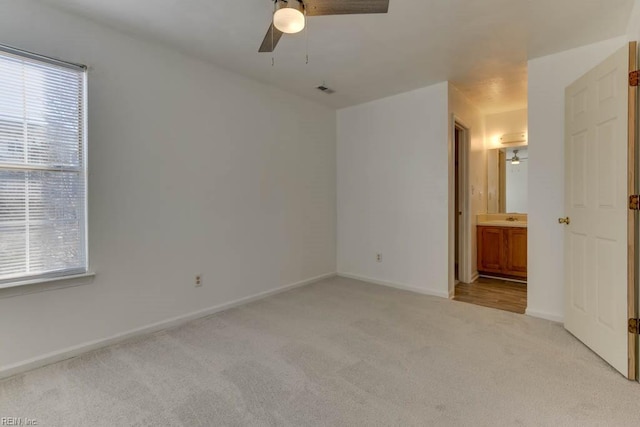 interior space with a healthy amount of sunlight, ceiling fan, light carpet, and sink