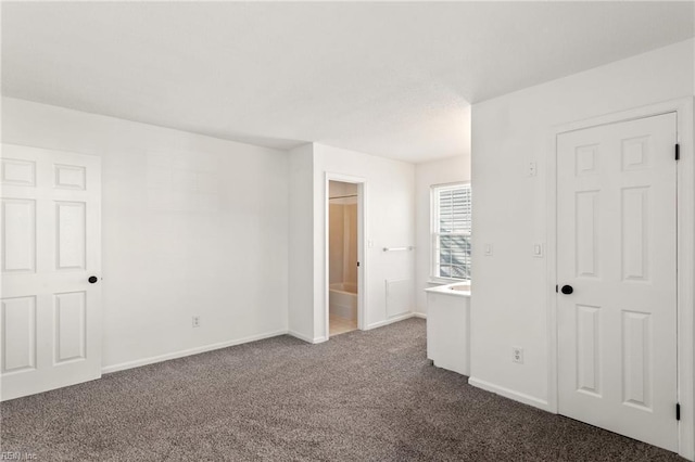 unfurnished room with dark colored carpet